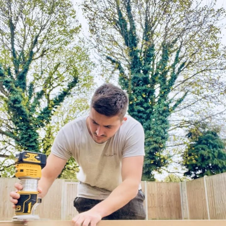 Josh Brunsdon using a router on a board outdoors