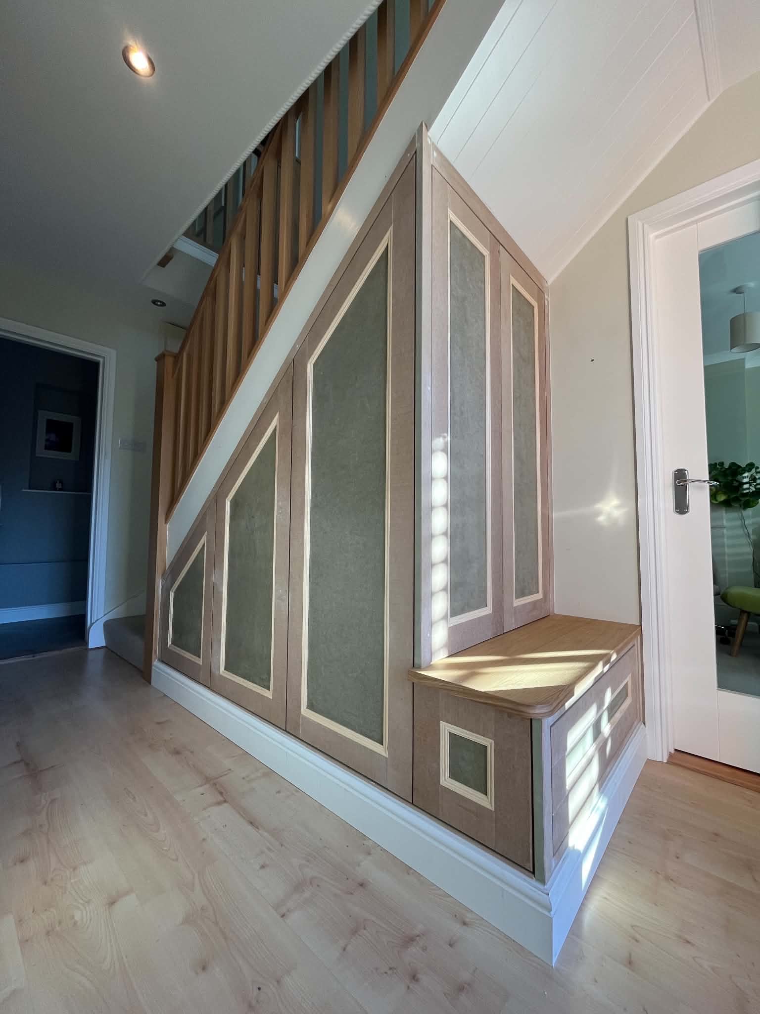 Under-stairs storage with beaded panels and a bench seat, fitted and ready for decorating
