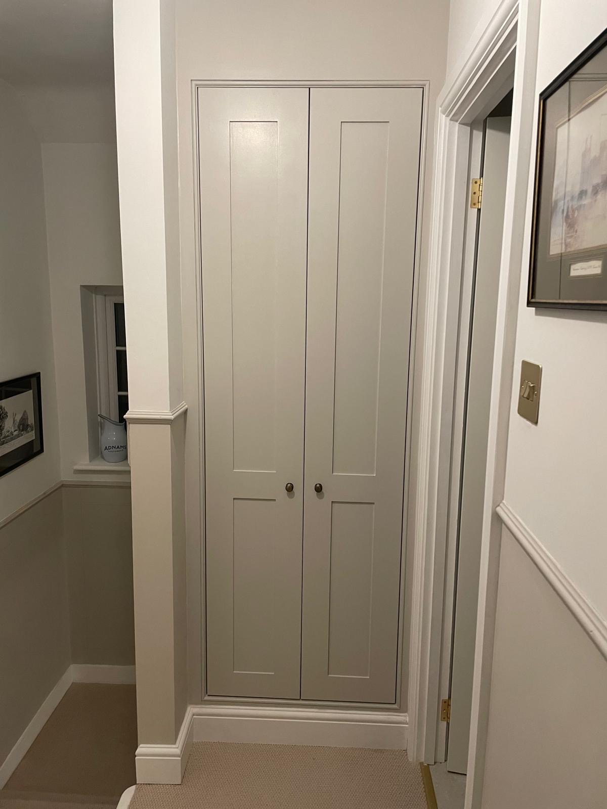 A painted shaker cupboard built into an unused space on a landing