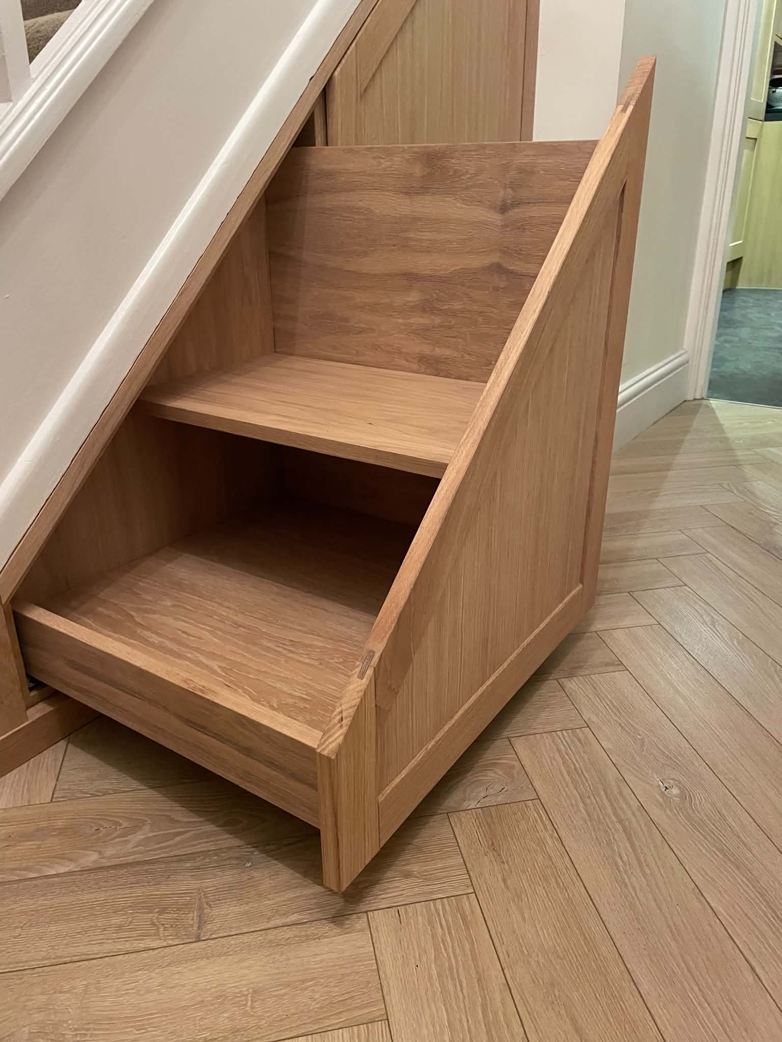 Oak pull-out drawers built into the space under a staircase